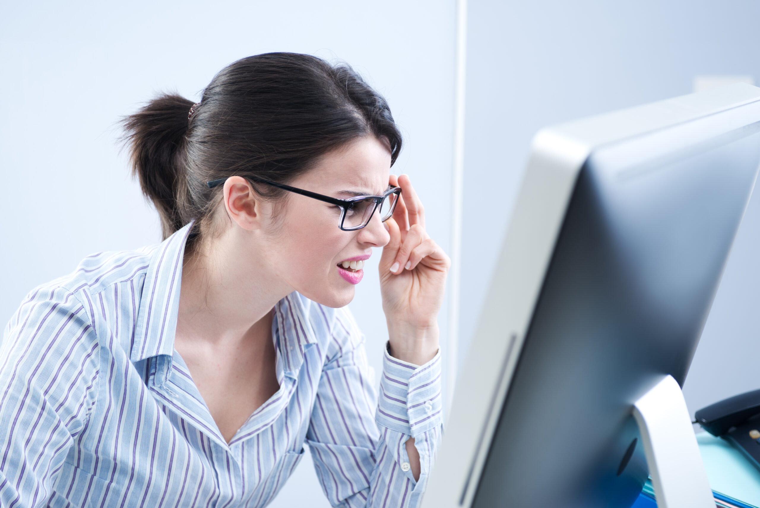stock image of a woman squinting for an article on how to make font size bigger